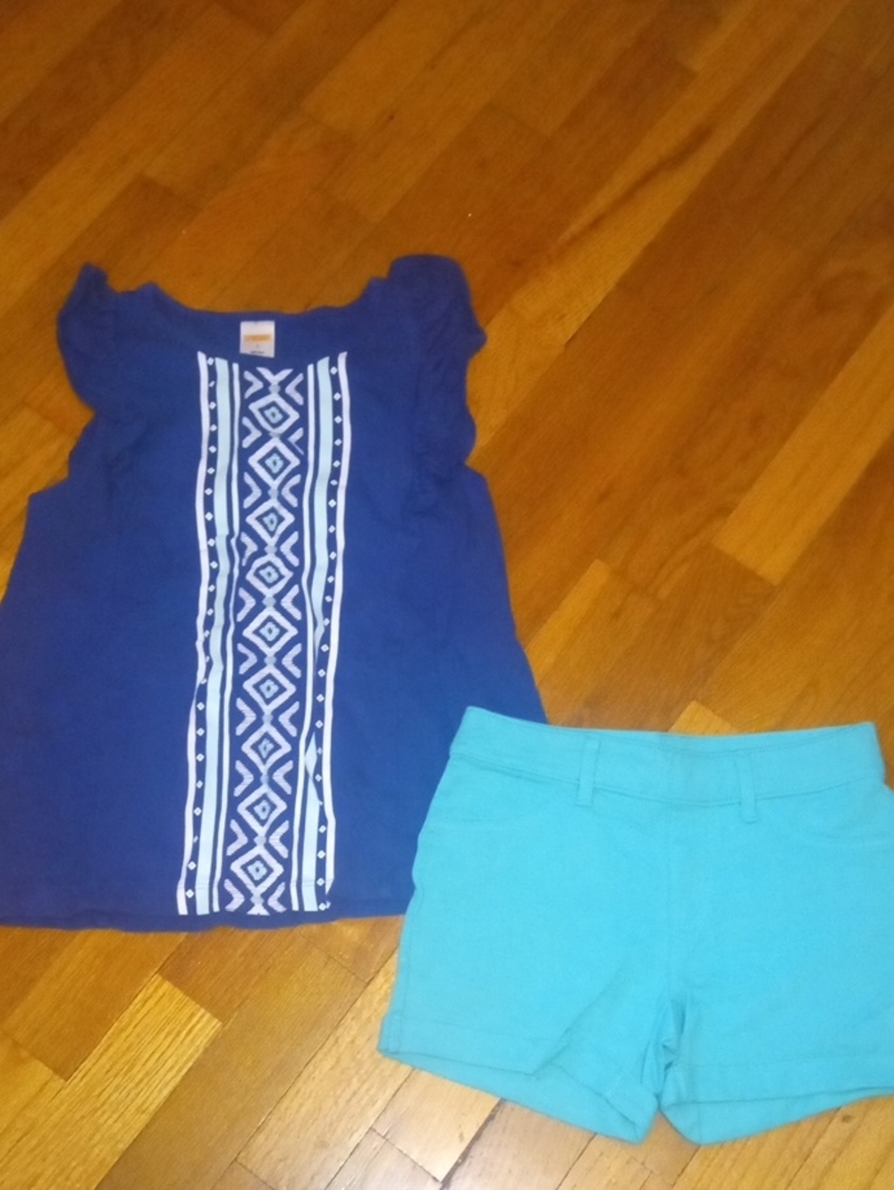 girl med 7-8 navy top with design and green shorts